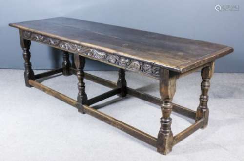 A good 17th Century oak refectory table with cleated three-plank top, the frieze carved with twin