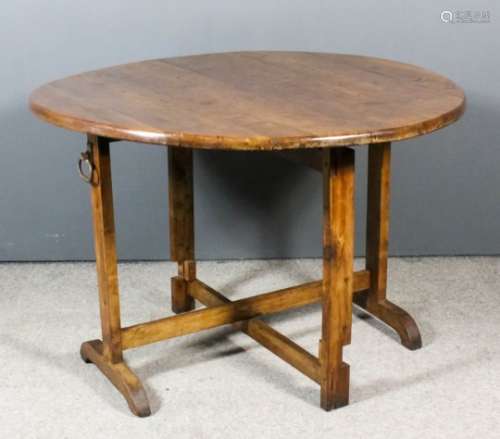 A French provincial fruitwood circular folding Vendange or wine tasting table, the six plank top