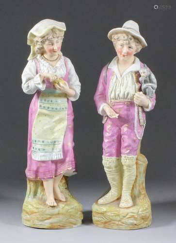 A pair of late 19th Century Continental bisque porcelain figures of a showman with magic lantern and