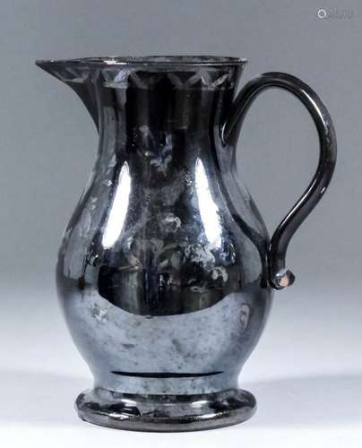 An 18th Century English Jackfield pottery jug with traces of an overglaze design in silver and