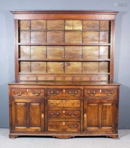 An 18th Century panelled oak dresser, the open top fitted three shelves and five small drawers,