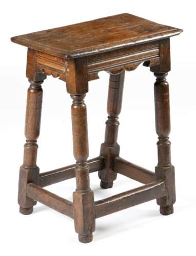 A mid-17th century oak joint stool, the seat with a moulded edge, above moulded bicuspid rails, on
