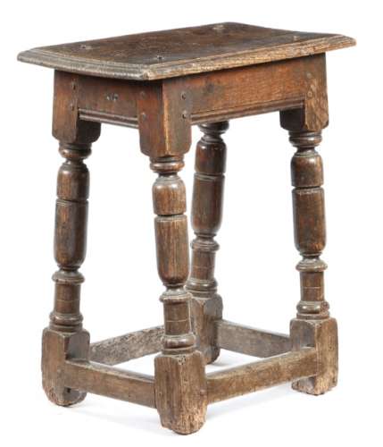 A mid-17th century oak joint stool, the seat with a moulded edge, the frieze branded with owner's
