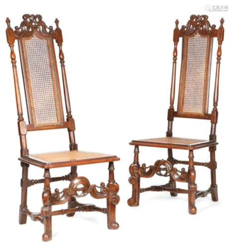 A pair of William and Mary walnut high back side chairs, each with a scroll carved surmount above