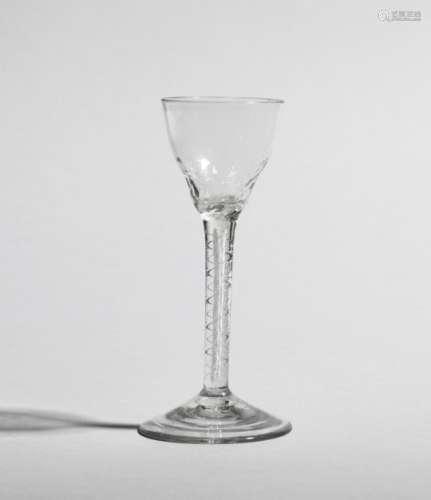 An unusual wine glass c.1760, the ogee bowl hammered around the base and raised on a double series