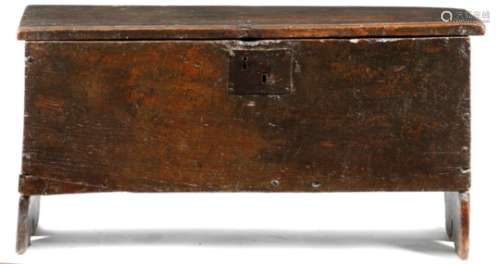 An early 17th century oak boarded coffer, the lid with crimped edges and incised zigzag