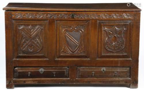 An early 18th century Welsh oak mule chest, the top with a moulded edge above a leaf and scroll