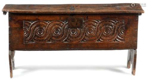A 17th century oak boarded coffer, the lid with crimped sides and incised zigzag decoration, with