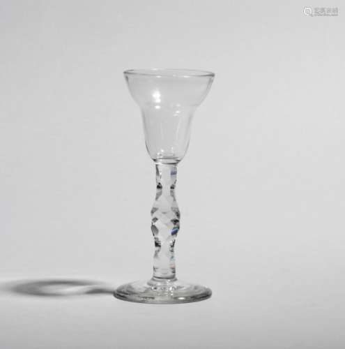 A wine glass c.1770, the pan-topped bowl raised on a knopped facet cut stem above a thick foot, 15.