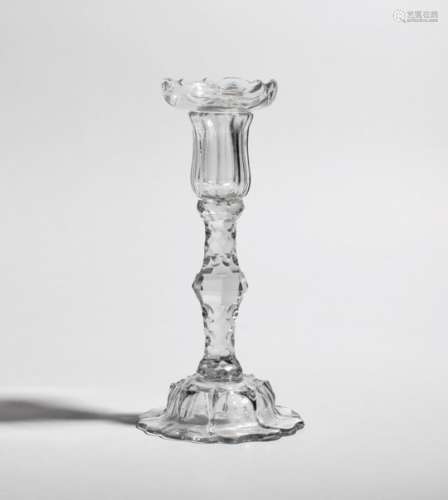A glass candlestick c.1760-70, the waisted nozzle moulded with vertical ribs, raised on a knopped