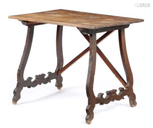 An 18th century Spanish walnut centre table, the boarded top on open scroll supports, the back