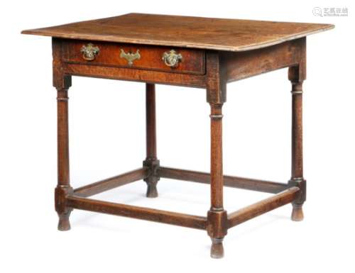 An early 18th century oak side table, the top with a moulded edge above a frieze drawer, on turned