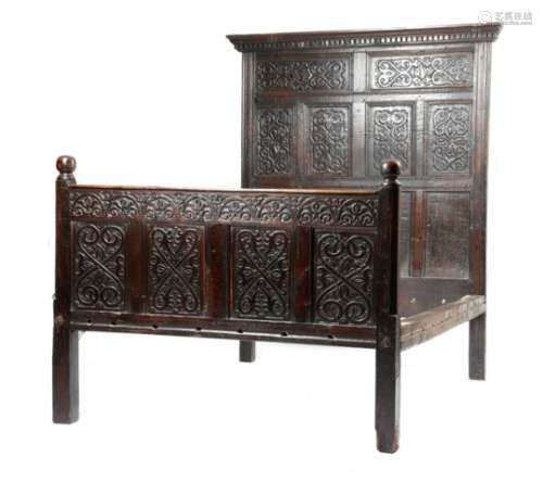 A 17th century oak bedstead, the headboard with a moulded dentil cornice above a pair of panels