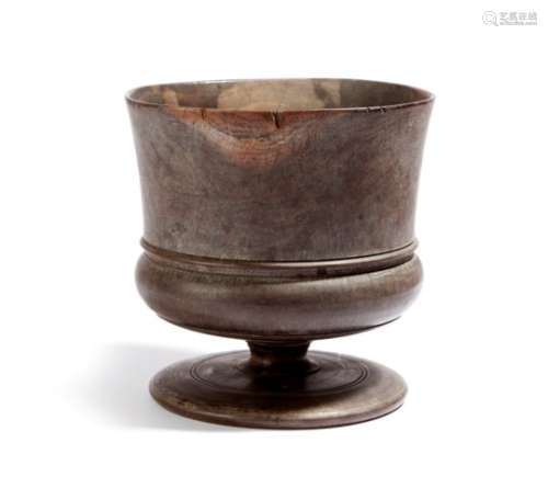 A mid-17th century treen lignum vitae wassail bowl, the everted rim above a single reeded girdle
