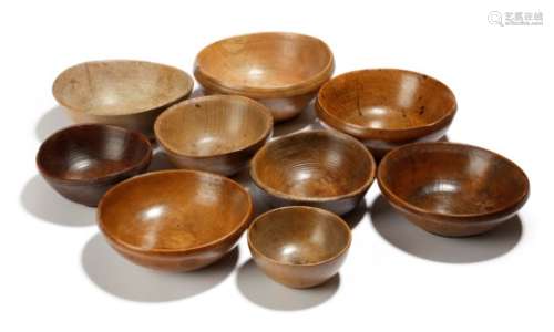 Nine treen feeding bowls, in sycamore, beech and other woods, with reeded and incised bands, one