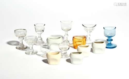 Nine glass eyebaths 19th and 20th centuries, most clear glass and raised on pedestal stems, one pale