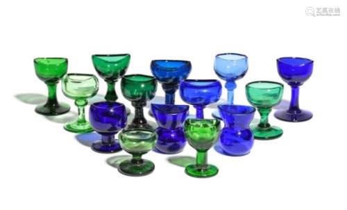 Fourteen coloured glass eyebaths 19th and 20th centuries, of varying shades of blue and green glass,