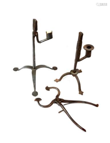 An 18th century wrought iron rushnip and candle holder on a tripod base, together with a similar