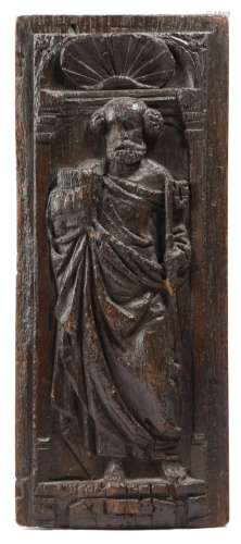 A 17th century carved oak panel, depicting Saint Peter, holding a key and a book, in an arched niche