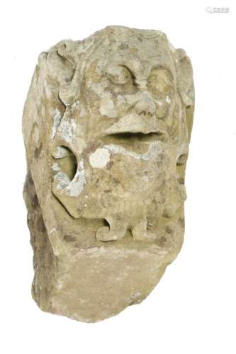 A 19th century carved sandstone gargoyle keystone in Gothic style, carved with a grotesque mask,