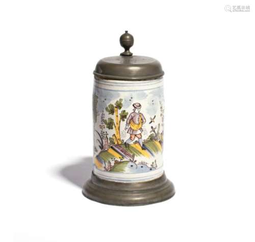 A German faïence tankard dated 1764, the cylindrical form painted in polychrome enamels with a