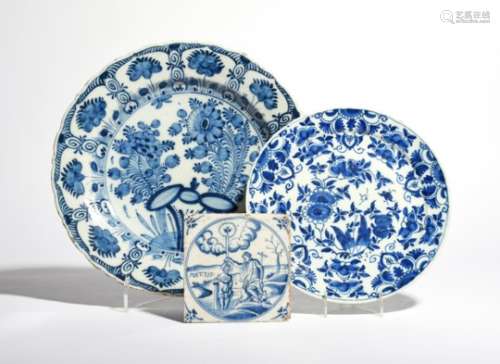 Two Delft plates c.1750-70, one of shallow pancake form, painted in blue with an allover floral