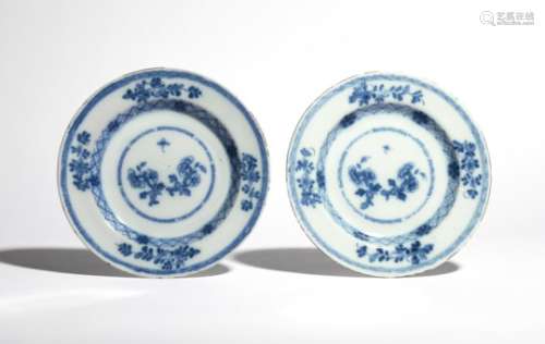 A pair of delftware plates c.1760, painted to the wells with flowering peony branches, echoed to the