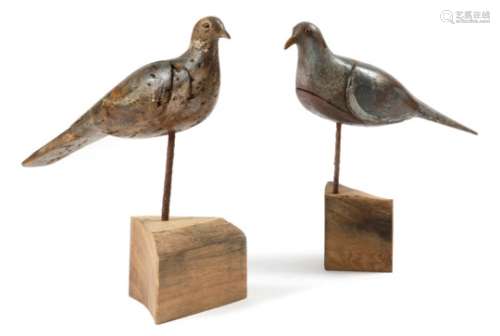 Two carved and painted pine decoy pigeons, each with glass eyes, mounted on a later wood stand, 33.