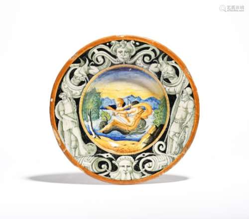 An Italian maiolica dish 19th century, the well painted with Neptune reclining on the back of a