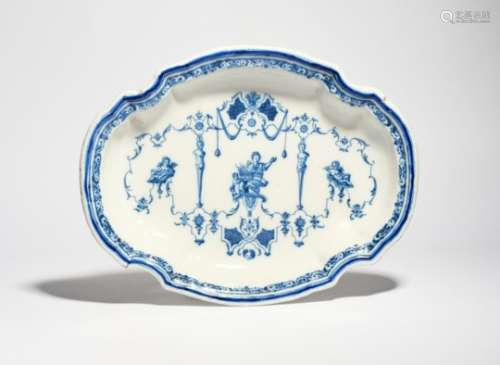 A Moustiers faience charger c.1720-40, the well painted in blue in the manner of Jean Bérain with