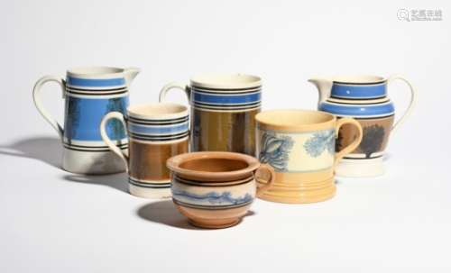 Three large mocha ware mugs and two jugs 19th century, and a large round cup or vomit pot, variously