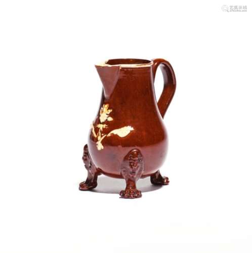 A Staffordshire glazed redware milk jug c.1745, the pear-shaped body sprigged with a flower spray in