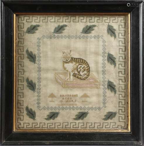 An early 19th century needlework sampler, worked with a cat seated on a cushion, with a band of