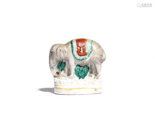 A small Staffordshire figure of an elephant 19th century, standing four square and caparisoned,