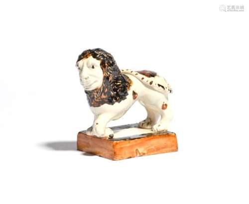 A creamware figure of a lion late 18th/early 19th century, modelled as a Medici Lion with his left