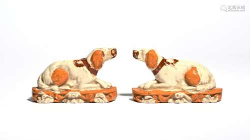 An unusual pair of flat back models of dogs 19th century, each recumbent with paws crossed and heads