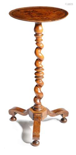 An early 18th century walnut candlestand, the dished circular top above a spiral twist stem and on