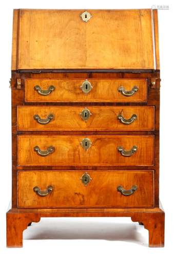 A small George II walnut bureau, the feather banded hinged fall revealing an interior fitted with