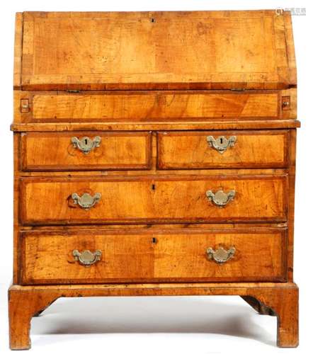 A George II walnut bureau, cross and feather banded, the hinged fall revealing an interior fitted