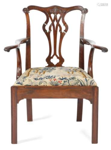 A George III mahogany open armchair, the serpentine top rail with carved floret ears and a pierced