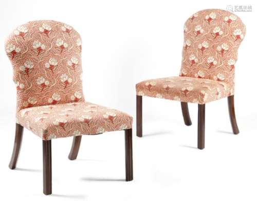 A pair of George III mahogany side chairs, each with a padded back and seat, on moulded and