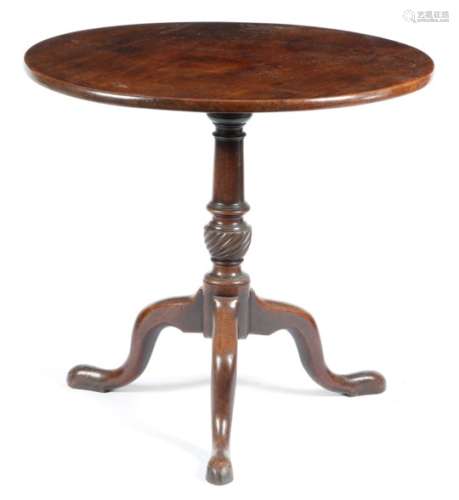 A George III mahogany tripod table, the circular tilt-top above a ring turned baluster stem with a