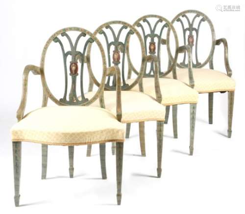 A set of four painted open armchairs in George III style, decorated with bands of flowers, husks and