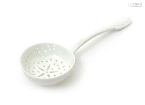 A French porcelain sugar ladle c.1750-70, the wide circular bowl pierced with rows of small holes