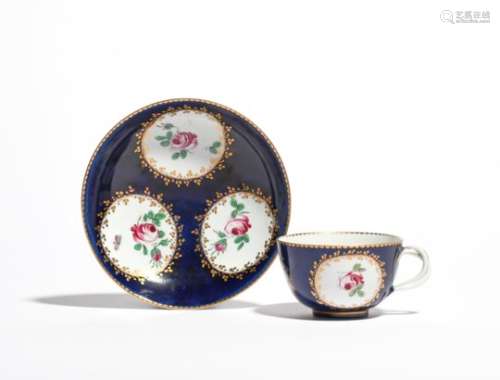 A Doccia cup and saucer c.1760-70, painted with three panels of pink roses reserved within narrow