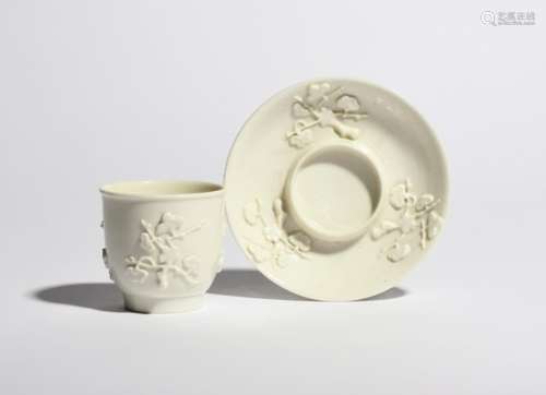 A St Cloud white-glazed beaker and saucer c.1720-30, of deep U-shape, the saucer with a trembleuse