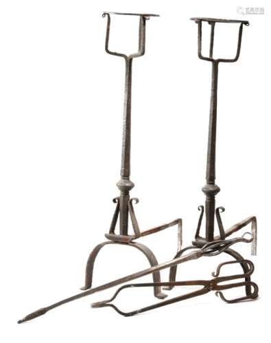 A pair of 18th century wrought iron fire dogs, each with a bottle holder top, with faceted stems,