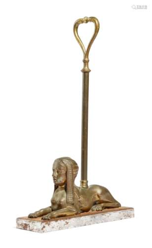 A 19th century brass doorstop, in the form of a sphinx, with a turned stem and loop handle, on a