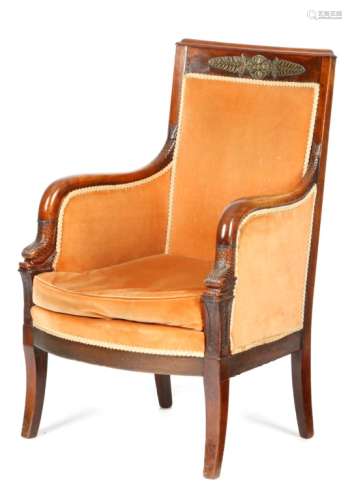 A 19th century French 'Empire' mahogany bergθre armchair, the flame veneered frieze applied with a