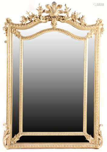 A French giltwood and gesso wall mirror in Rιgence style, with an arched and bevelled central plate,